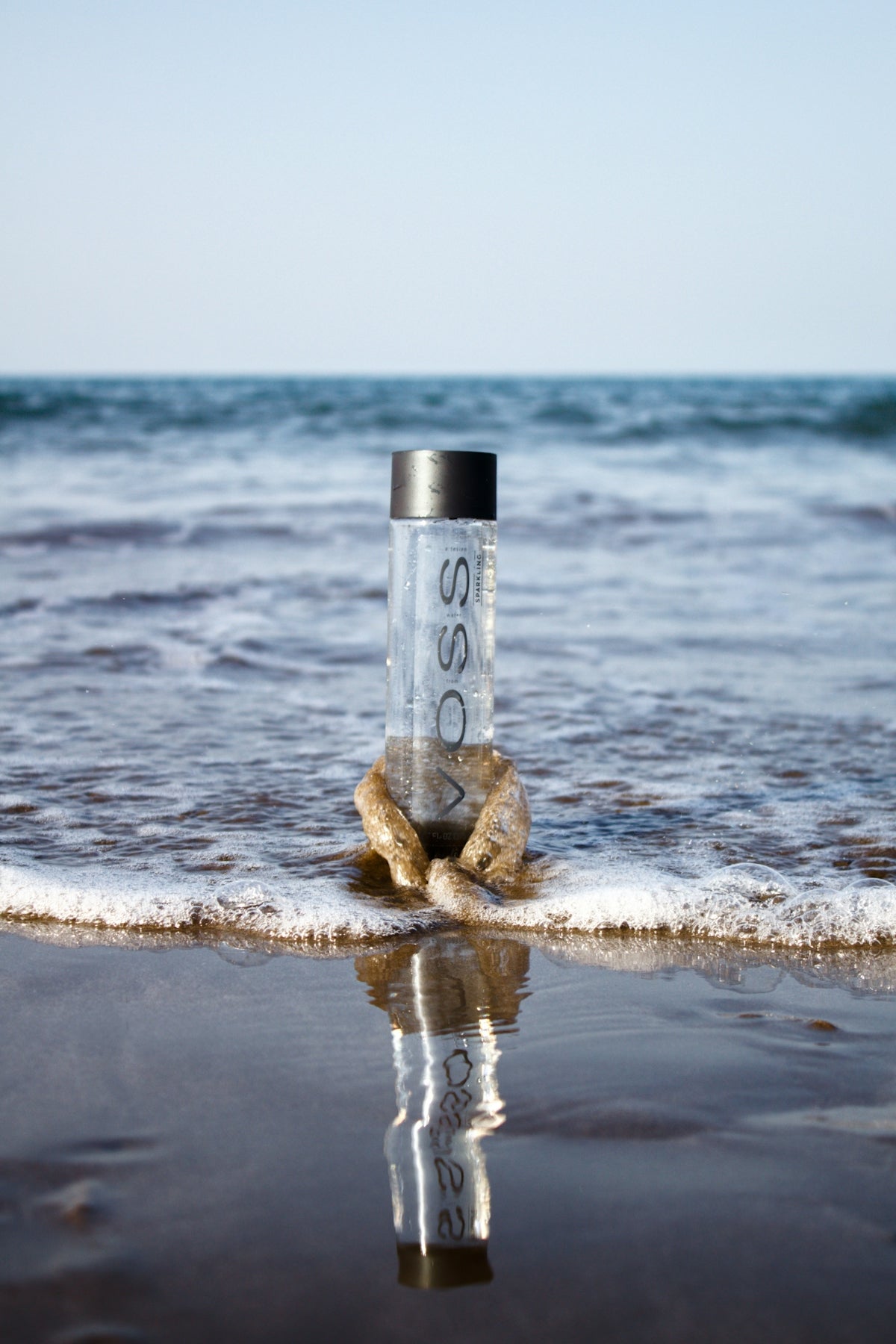 clear glass bottle on beach shore during daytime