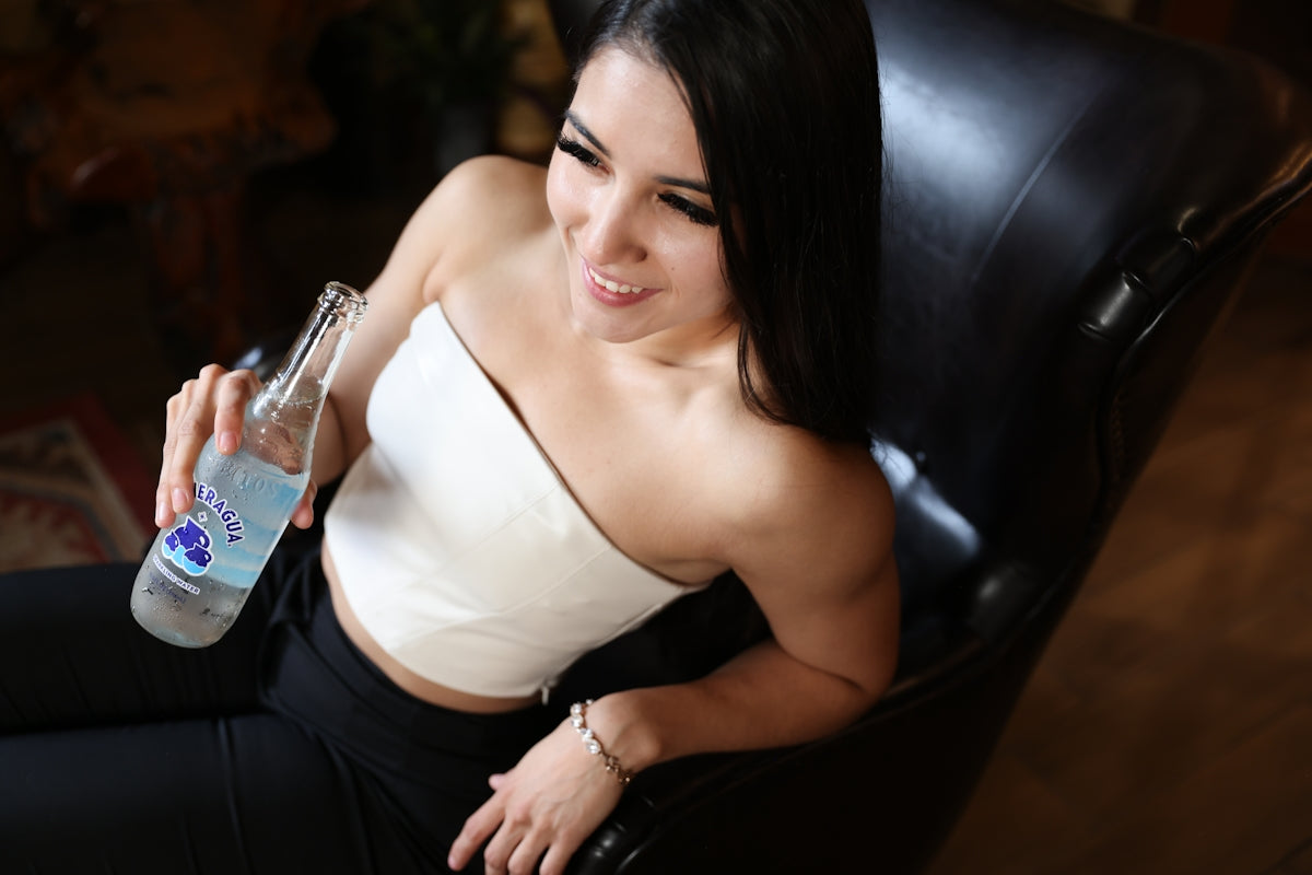 a woman sitting in a chair holding a bottle of water
