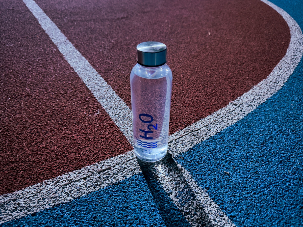 a bottle of water sitting on a tennis court